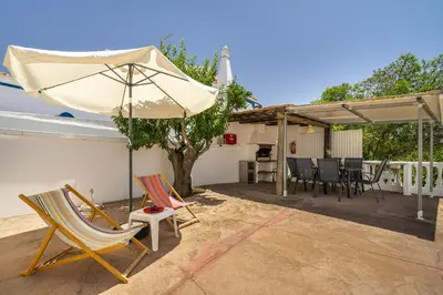 a patio with two chairs and an umbrella at Casa Solar in Guia