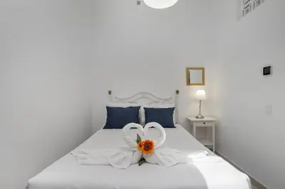 a white bed with two white towels and flowers on it at Casa Solar in Guia