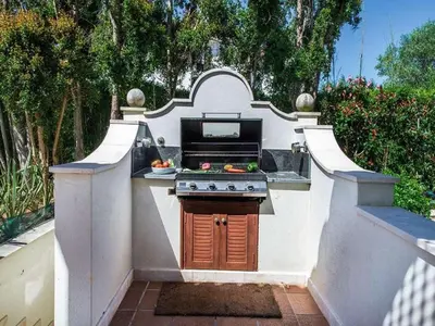 a outdoor kitchen with a stove in a backyard at Exquisite Quinta Da Lago Villa Villa Majestic Heights 4 Bedrooms in Almancil