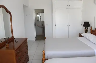 a bedroom with two beds and a dresser and a mirror at Casa Oura Sea Living in Albufeira