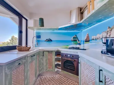 a kitchen with a table and a tv on the wall at AL - Apartamento Algardia Mar in Vilamoura