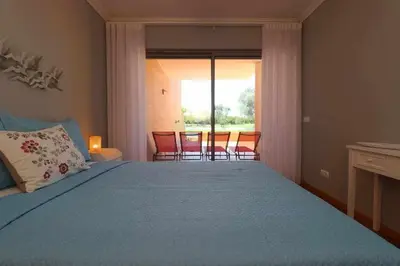 a bedroom with a bed and a table and chairs at Millennium golf by FHR piscina & parking in Vilamoura