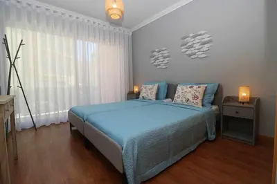 a bedroom with a blue bed and a window at Millennium golf by FHR piscina & parking in Vilamoura
