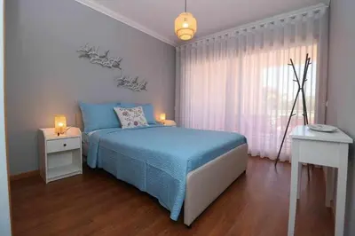 a bedroom with a blue bed and a window at Millennium golf by FHR piscina & parking in Vilamoura