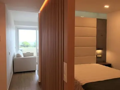 a bedroom with a bed and a room with a window at Great sea view apartment, near the beach, with AC and pools in Albufeira