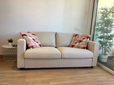 a white couch with two pillows on it in a living room at Great sea view apartment, near the beach, with AC and pools in Albufeira