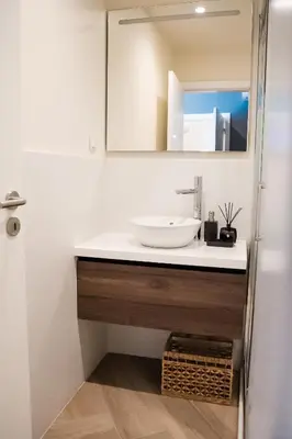 a bathroom with a sink and a mirror at Guest House Jacarandá Faro in Faro