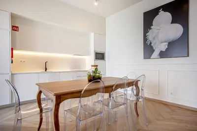 a dining room with a wooden table and chairs at Guest House Jacarandá Faro in Faro