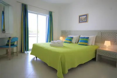 a bedroom with a large yellow bed with a window at The Sun - Clube Albufeira Garden Village in Albufeira