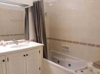 a bathroom with a sink and a tub and a shower at The Sun - Clube Albufeira Garden Village in Albufeira