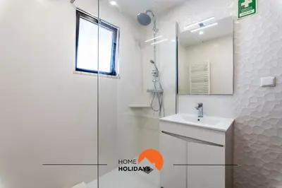 a bathroom with a shower and a sink and a mirror at #169 T3 Medronheira by Home Holidays in Albufeira