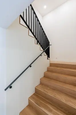a staircase with wood treads and white walls at Compromisso 25 in Faro