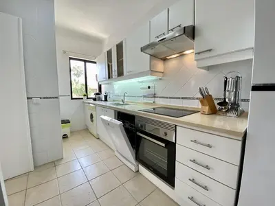 a white kitchen with a sink and a stove at Vilamoura Twins 1 With Pool by Homing in Vilamoura