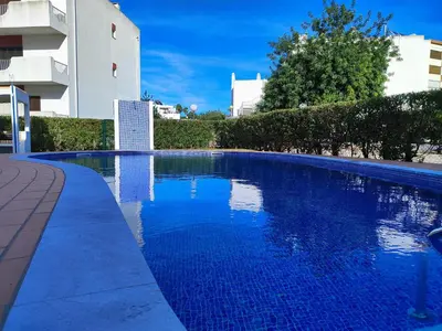 a large blue swimming pool next to a building at Vilamoura Twins 1 With Pool by Homing in Vilamoura