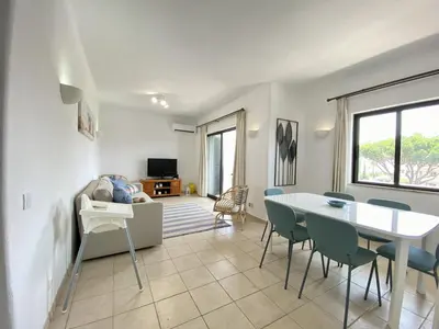 a living room with a table and chairs and a couch at Vilamoura Twins 1 With Pool by Homing in Vilamoura