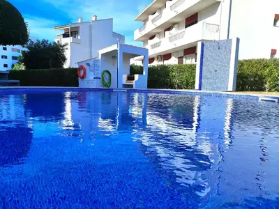 a large blue swimming pool in front of a building at Vilamoura Twins 1 With Pool by Homing in Vilamoura