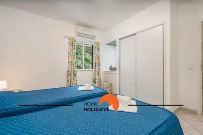 a bedroom with a blue bed with a home holidays sign on it at #174 T2 em Zona Tranquila by Home Holidays in Albufeira
