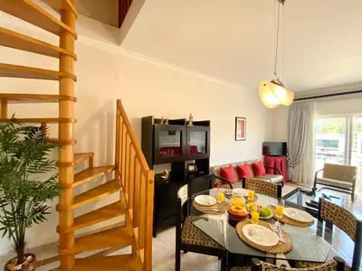a living room with a table and a dining room at Vilamoura Typical 2 With Pool by Homing in Vilamoura