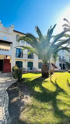 a palm tree in front of a building at Charming triplex T2 in the Old Village Vilamoura in Quarteira