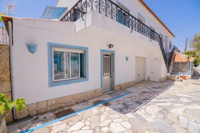 a white house with a balcony on top of it at Casinha I by Innkeeper in Guia