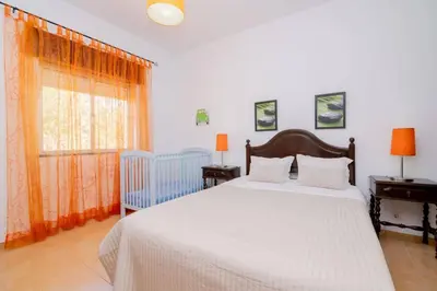 a bedroom with a bed and a crib and a window at Casinha I by Innkeeper in Guia