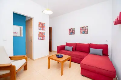a living room with a red couch and a table at Casinha I by Innkeeper in Guia