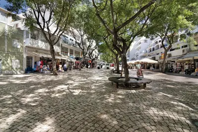 a street with cars parked on the side of a building at Hanna's Sunny Apartment in Albufeira