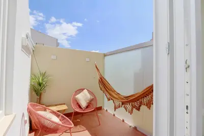 a balcony with a hammock and a table and chairs at Marina Vista Sol-CleverDetails, Marina view, sleeps 2 adults and 2 children in Vilamoura
