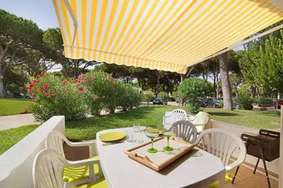 a white table and chairs under a yellow umbrella at Aldeia das açoteias in Albufeira