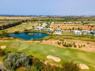 an aerial view of a golf course with a lake at Mourabel Apartment - S by HelloVacations in Loulé