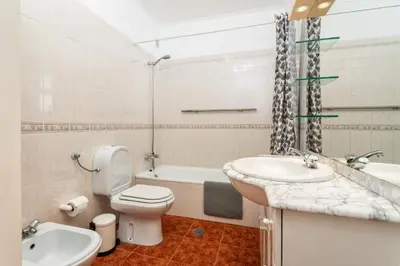 a bathroom with a sink and a toilet and a tub at Host Wise - Amazing Sunny Flat - Swimming Pool & Terrace in Vilamoura