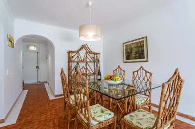 a dining room with a glass table and chairs at Host Wise - Amazing Sunny Flat - Swimming Pool & Terrace in Vilamoura