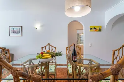 a dining room with a table and chairs with a bowl of fruit at Host Wise - Amazing Sunny Flat - Swimming Pool & Terrace in Vilamoura