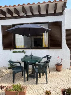 a table and chairs with an umbrella on a patio at Sunny Villa with golf front view in Vilamoura