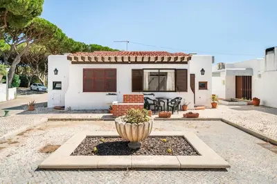 a house with a fountain in front of it at Sunny Villa with golf front view in Vilamoura