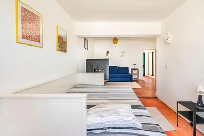 a living room with two beds and a blue couch at Sunny Villa with golf front view in Vilamoura