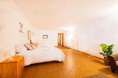 a white bedroom with a bed and a table at Villa Arrifes by Atlantic Places in Albufeira