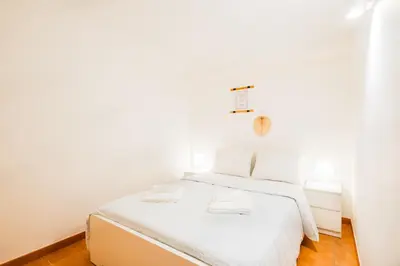 a white bedroom with a bed with white sheets at Villa Arrifes by Atlantic Places in Albufeira