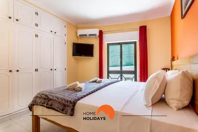 a bedroom with a bed with a tv on the wall at #180 T2 Ondas do Mar by Home Holidays in Albufeira