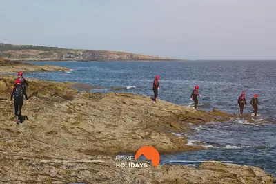 a group of people walking on the rocks near the water at #180 T2 Ondas do Mar by Home Holidays in Albufeira