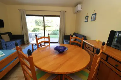 a dining room with a wooden table and chairs at Studio Camélia 67 at São Rafael Beach - Albufeira in Albufeira