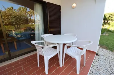 a white table and four chairs on a patio at Studio Camélia 67 at São Rafael Beach - Albufeira in Albufeira