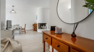 a living room with a table and a mirror at 1 BDR Vilamoura Escape W Patio by LovelyStay in Quarteira