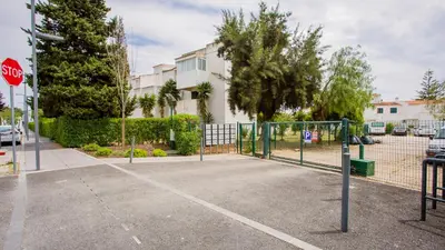 a tennis court in a parking lot with a stop sign at 1 BDR Vilamoura Escape W Patio by LovelyStay in Quarteira