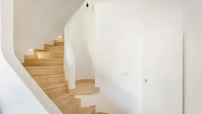 a staircase in a house with white walls and wooden floors at 2 BDR Vilamoura Escape W Balcony by LovelyStay in Quarteira