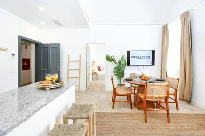 a kitchen and dining room with a table and chairs at Doce Faro Niente Apartment in Faro