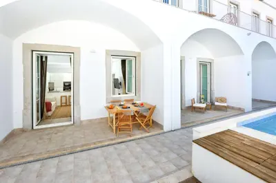 a villa with a swimming pool and a patio at Doce Faro Niente Apartment in Faro