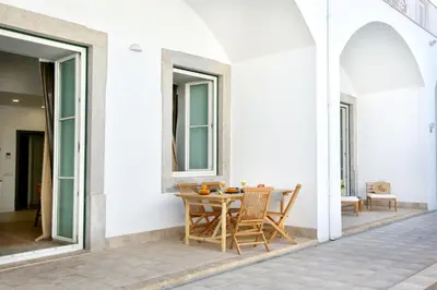 a patio with a table and chairs on a house at Doce Faro Niente Apartment in Faro