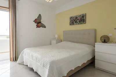 a bedroom with a bed with a butterfly on the wall at Horizonte - Sea view by HD PROPERTIES in Quarteira