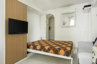a small bedroom with a bed and a flat screen tv at Horizonte - Sea view by HD PROPERTIES in Quarteira